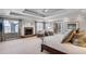 Bright main bedroom with large windows, fireplace, neutral carpeting, tray ceiling, sitting area, and walk-in closet at 24 Ball Creek Hl, Atlanta, GA 30350