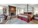 Spacious bedroom features a fireplace, sitting area, and a four-poster bed with hardwood flooring at 24 Ball Creek Hl, Atlanta, GA 30350