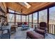 Inviting screened porch with wood-paneled ceiling, brick accents, and a comfortable seating arrangement at 24 Ball Creek Hl, Atlanta, GA 30350