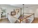 Bright foyer staircase adorned with art and natural lighting through an open bedroom doorway, hardwood flooring, and carpeted stairs at 24 Ball Creek Hl, Atlanta, GA 30350