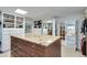 Custom walk-in closet with center island, custom shelves and drawers, and connecting bathroom through double doors at 24 Ball Creek Hl, Atlanta, GA 30350