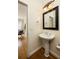 This powder room features a pedestal sink with decorative mirror and lighting at 276 Atlanta Se Ave, Atlanta, GA 30315