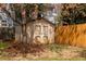 Backyard shed with wood doors and siding with a tree and wooden fence at 276 Atlanta Se Ave, Atlanta, GA 30315