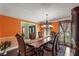 Elegant dining room featuring a chandelier, orange walls, an ornate dining table and chairs, and sophisticated window treatments at 308 Paper Woods Dr, Lawrenceville, GA 30046