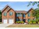 Charming brick home with green shutters, manicured landscaping, and a spacious driveway with a large three-car garage at 308 Paper Woods Dr, Lawrenceville, GA 30046