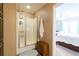 Bathroom featuring a glass enclosed shower with shelving next to the main bedroom at 7024 Evergreen Way, Buford, GA 30518