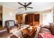 Cozy living room with a ceiling fan, plush leather seating, and ample space for relaxation at 7024 Evergreen Way, Buford, GA 30518