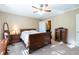 The bedroom is decorated in neutral tones with a window, fan, and dark wood furniture at 7024 Evergreen Way, Buford, GA 30518