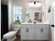 Bright bathroom featuring a double vanity, a toilet, and a shower with a black shower curtain at 8The07 Stickley Oak Way, Woodstock, GA 30189