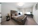 Bedroom with a large window, neutral walls, and a cozy sitting area next to the bed at 8The07 Stickley Oak Way, Woodstock, GA 30189