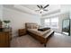 Spacious bedroom featuring a ceiling fan, tray ceiling, carpeted floor, and large windows with a view at 8The07 Stickley Oak Way, Woodstock, GA 30189