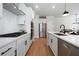 Modern kitchen with white cabinetry, stainless steel appliances, and a center island with a black faucet at 8The07 Stickley Oak Way, Woodstock, GA 30189