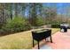 Well maintained backyard featuring a garden bed, patio, and a lush wooded area at 2296 Raven Cir, Lithonia, GA 30058
