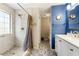Updated bathroom with tiled shower, decorative floor tiles, and stylish fixtures, and blue accent wall at 2296 Raven Cir, Lithonia, GA 30058