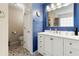 Beautiful bathroom featuring blue walls, a white vanity with a large mirror, and decorative tile floors at 2296 Raven Cir, Lithonia, GA 30058