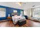 Bright bedroom with hardwood floors, blue accent wall, chair, and large windows for lots of natural light at 2296 Raven Cir, Lithonia, GA 30058