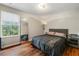 Cozy bedroom with hardwood floors, large window, and a comfortable bed with black comforter at 2296 Raven Cir, Lithonia, GA 30058