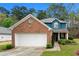 Charming two-story home with brick accents, a white garage door, and a well-manicured lawn at 2296 Raven Cir, Lithonia, GA 30058