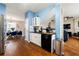 Modern kitchen with white cabinets, black appliances, and an adjacent dining area with blue chairs at 2296 Raven Cir, Lithonia, GA 30058