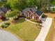 Aerial shot of a brick home with a well-manicured lawn, driveway, and surrounding trees at 500 Meadowmeade Ln, Lawrenceville, GA 30043