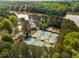 Overhead view featuring tennis courts, community center with pool, and lake access surrounded by mature trees at 500 Meadowmeade Ln, Lawrenceville, GA 30043
