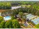An aerial image highlights a community pool, clubhouse, and tennis courts nestled within a lush, wooded landscape near a lake at 500 Meadowmeade Ln, Lawrenceville, GA 30043