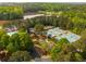 A stunning aerial view showcases a community clubhouse, swimming pool, and tennis courts near a lake and surrounded by lush trees at 500 Meadowmeade Ln, Lawrenceville, GA 30043