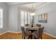 Elegant dining room features a round glass table, stylish chairs, wood floors, and plantation shutters at 500 Meadowmeade Ln, Lawrenceville, GA 30043