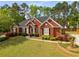 Beautiful brick home with lush green lawn, mature trees, and a basketball hoop in the driveway at 500 Meadowmeade Ln, Lawrenceville, GA 30043