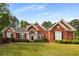 Charming red brick home with a well-manicured lawn and mature landscaping at 500 Meadowmeade Ln, Lawrenceville, GA 30043
