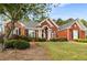 Attractive brick home with a spacious front lawn and mature trees providing shade at 500 Meadowmeade Ln, Lawrenceville, GA 30043