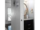 Stylish powder room showcasing a vanity with black cabinets, marble countertop, and an oval mirror with gold accents at 6972 Sandtown Ln, Stone Mountain, GA 30087