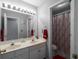 Bathroom featuring a double vanity with a large mirror and a shower with a patterned curtain at 6972 Sandtown Ln, Stone Mountain, GA 30087