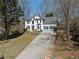 Two-story home boasting a grey roof, a long driveway and an inviting landscaped front yard at 6972 Sandtown Ln, Stone Mountain, GA 30087