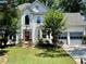 Charming two-story home with manicured lawn, mature trees, and a gray two-car garage at 6972 Sandtown Ln, Stone Mountain, GA 30087