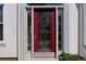 Close-up of a red front door framed by sidelights and decorative trim at 6972 Sandtown Ln, Stone Mountain, GA 30087