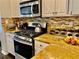 Bright kitchen featuring granite countertops, stainless steel appliances, and a stylish backsplash at 6972 Sandtown Ln, Stone Mountain, GA 30087