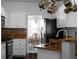 Kitchen with white cabinets and stone countertops that leads to a dining area with stylish chandelier at 6972 Sandtown Ln, Stone Mountain, GA 30087