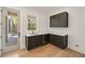 Wet bar boasts dark cabinetry, stone countertops, sink, and door leading to outdoor patio at 1068 Moores Mill Nw Rd, Atlanta, GA 30327