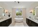 Bright bathroom features a soaking tub, dual vanities, and modern fixtures at 1068 Moores Mill Nw Rd, Atlanta, GA 30327
