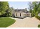 View of a grand two-story home with a three-car garage, surrounded by mature trees and a well-manicured lawn at 1068 Moores Mill Nw Rd, Atlanta, GA 30327