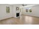 Bright living room with fireplace, ceiling fan, hardwood floors, and many windows at 1068 Moores Mill Nw Rd, Atlanta, GA 30327