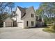 Wide exterior shot featuring a white brick two-story home with a three car garage and concrete driveway at 1074 Moores Mill Nw Rd, Atlanta, GA 30327