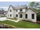 Charming two-story home featuring white brick, black-trimmed windows, manicured lawn, and concrete driveway at 1074 Moores Mill Nw Rd, Atlanta, GA 30327