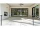 Covered patio with painted brickwork, ceiling fan, stone floor, and full-sized sliding glass doors to interior at 1074 Moores Mill Nw Rd, Atlanta, GA 30327