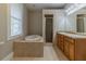 Luxurious bathroom with a garden tub, walk-in shower, double vanity, and tile floors at 1124 Lawton Sw Pl, Atlanta, GA 30310