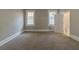 Spacious bedroom with neutral walls and carpet, featuring two windows and a door to the bathroom at 1124 Lawton Sw Pl, Atlanta, GA 30310