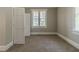 Bedroom with neutral walls and carpet, featuring a large window and a double door closet at 1124 Lawton Sw Pl, Atlanta, GA 30310