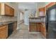 Traditional kitchen with oak cabinets and black appliances near a staircase with white railings at 1124 Lawton Sw Pl, Atlanta, GA 30310