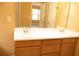 Bathroom with a double vanity with a white countertop and light wood cabinets, along with a large mirror at 1972 Ashwood Grove Dr, Snellville, GA 30078